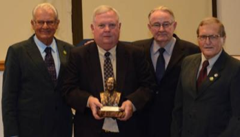 Bill Phillips, second from left, is presented with a bust of his father from Manoel Pereira, Franke Dijkstra and Herbert Bartz. 